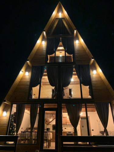 a house with a large window at night at Hidden Cabin in Brezoi