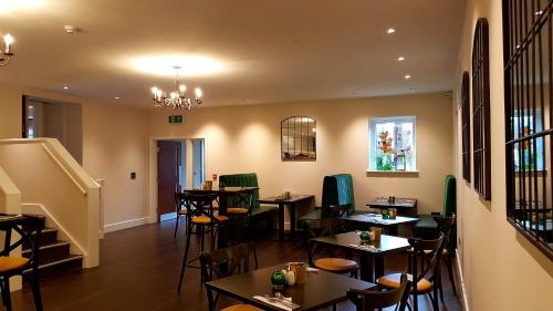 a restaurant with tables and chairs and a chandelier at Grains Bar Hotel in Oldham