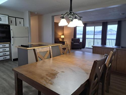 a kitchen and dining room with a large wooden table and chairs at Richter Pass Beach Resort in Osoyoos
