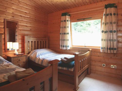 een slaapkamer met 2 bedden in een blokhut bij Cider Mill Lodge - Hw7420 in Tintern