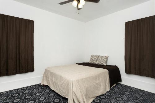1 dormitorio con 1 cama y ventilador de techo en A cozy home with fire place, en Detroit