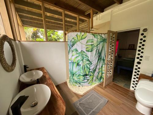 La salle de bains est pourvue d'un lavabo, de toilettes et d'une fenêtre. dans l'établissement Tesoro Escondido Ecolodge Cabinas, à Bocas del Toro
