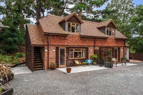 a brick house with some chairs on a gravel driveway at Hamble Retreat Studios and Lodge in Warsash