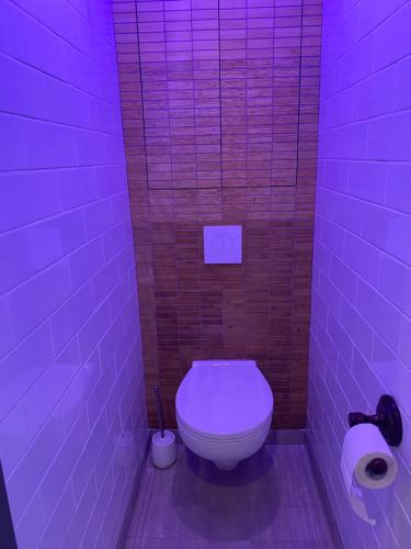łazienka z toaletą w fioletowym świetle w obiekcie Apartments in Kauguri w Jurmale
