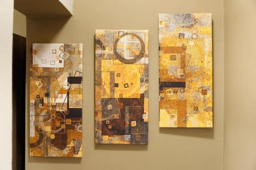 three pieces of art hanging on a wall at Garden house in Neapolis
