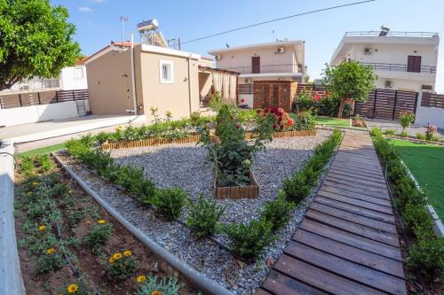 a garden with plants and a wooden walkway at Garden house in Neapolis