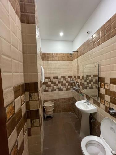 a bathroom with a toilet and a sink at Shree Krishna Hotels in Amritsar