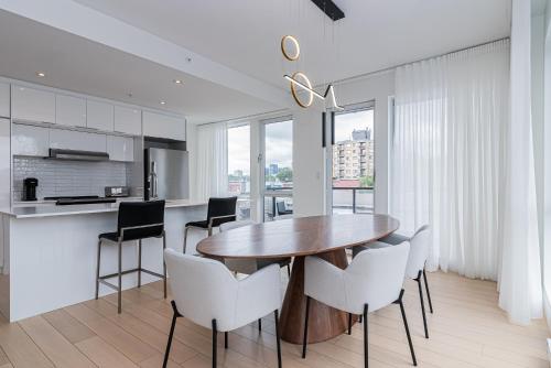 a kitchen and dining room with a wooden table and chairs at Le Se7t Penthouses in Montréal