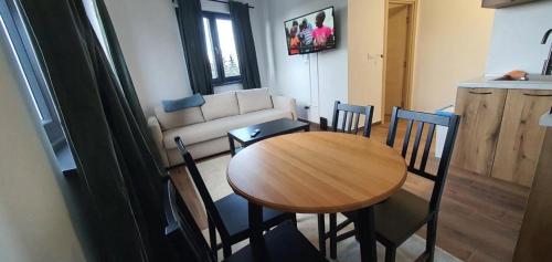 un salon avec une table et des chaises en bois dans l'établissement MONTANA apartment 21, à Kopaonik