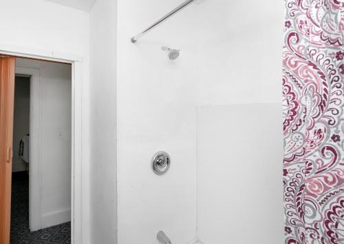 a white bathroom with a shower and a mirror at A cozy home with fire place in Detroit