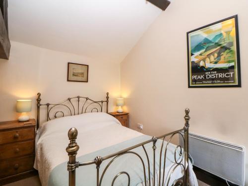 een slaapkamer met een bed en een foto aan de muur bij Harry Eyre Cottage in Castleton