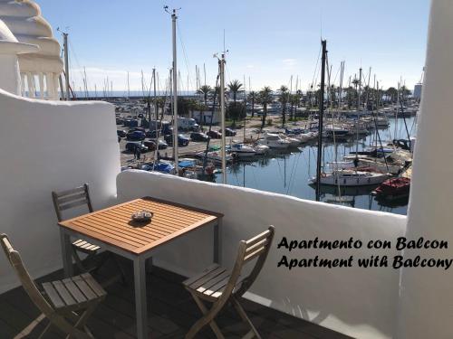a table and chairs on a balcony with a marina at Puerto Marina waterfront apartment in Benalmádena