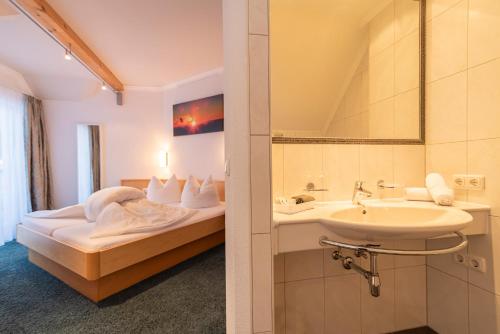 a hotel room with a bed and a sink at Hotel Garni Martina in Ischgl