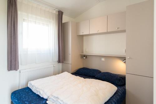een slaapkamer met een groot wit bed en een raam bij waddenlief in Ballum