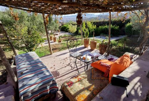une terrasse avec un canapé, une table et des chaises dans l'établissement Dar Boumida, à Lalla Takerkoust