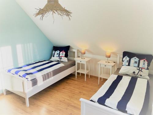 1 Schlafzimmer mit 2 Betten und 2 Tischen in der Unterkunft Haus-Am-See-Pratzschwitz in Pirna