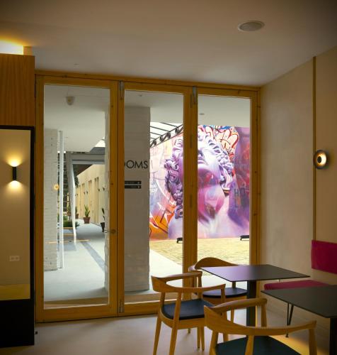 a room with tables and chairs and a painting on the wall at Mythic Valencia in Valencia