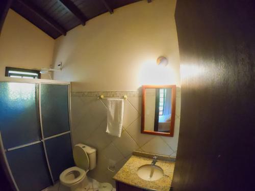 a bathroom with a toilet and a sink and a shower at Pousada Flor de Lotus in Praia do Rosa