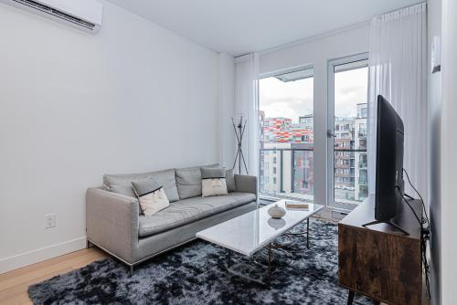 a living room with a couch and a flat screen tv at Le Se7t Penthouses in Montréal