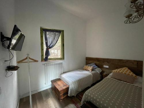 een slaapkamer met 2 bedden en een raam bij Stunning 4-Bed Cottage in Montseny Natural Park in Arbúcies