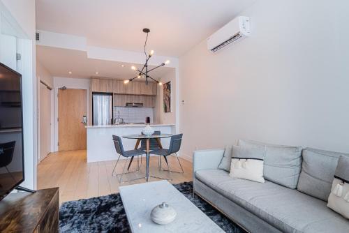 a living room and kitchen with a couch and a table at Le Se7t Penthouses in Montréal