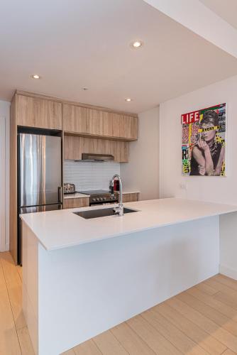 a kitchen with a white counter top and a refrigerator at Le Se7t Penthouses in Montréal