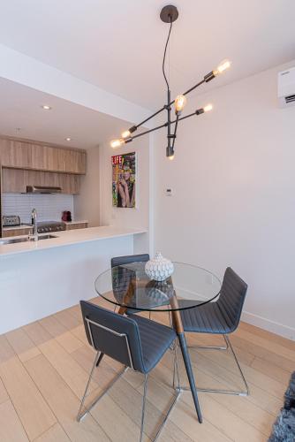 a dining room with a glass table and two chairs at Le Se7t Penthouses in Montréal