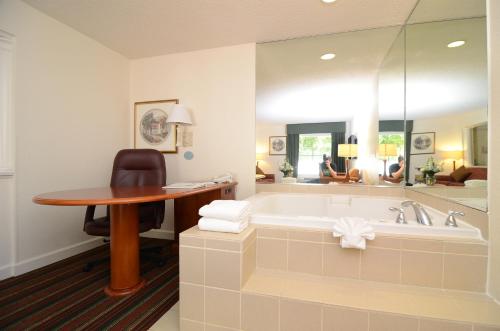 a bathroom with a tub and a table and a desk at Quality Inn & Suites Biltmore East in Asheville