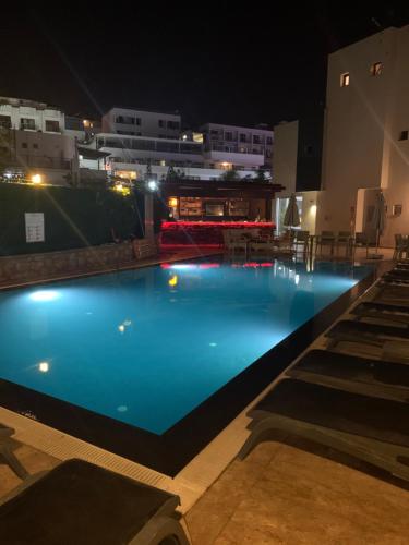 a large blue swimming pool at night at Orya Aparts in Gümbet