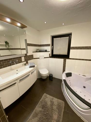 uma casa de banho com uma banheira, um WC e um lavatório. em Hochheide Lodge em Winterberg