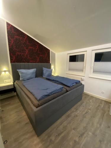ein Schlafzimmer mit einem Bett und zwei Fenstern in der Unterkunft Hochheide Lodge in Winterberg