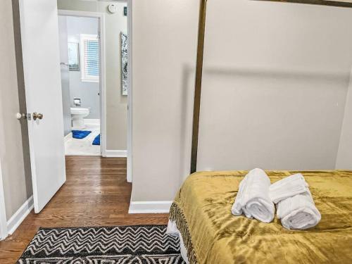 a bedroom with a bed with two towels on it at Rare Find! Cheerful & Spacious Home Ready for YOU! in Charlotte