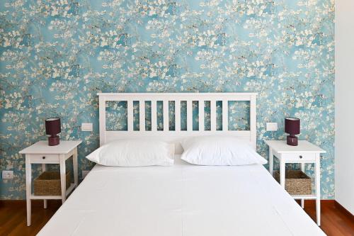 a bedroom with a white bed with two night stands at [Casa Gisa]Splendida terrazza nel cuore del centro in Città di Castello