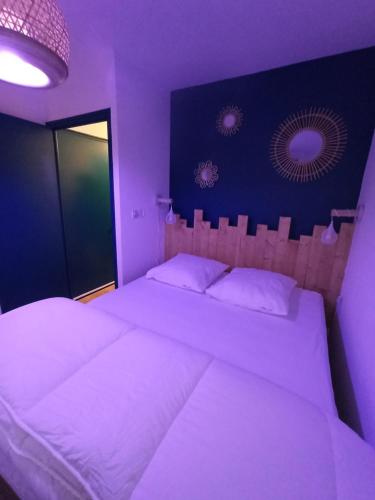 - une chambre violette avec 2 lits et des draps blancs dans l'établissement La Baie L’Etoile, Apt 4 pers, bord de mer, parking privé, Fort Mahon Plage, à Fort-Mahon-Plage