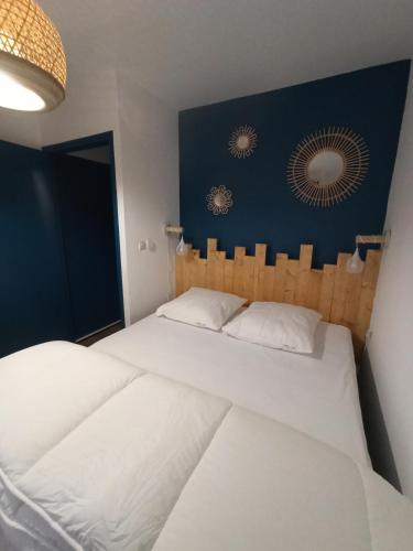 a bedroom with two white beds and a blue wall at La Baie L’Etoile, Apt 4 pers, bord de mer, parking privé, Fort Mahon Plage in Fort-Mahon-Plage