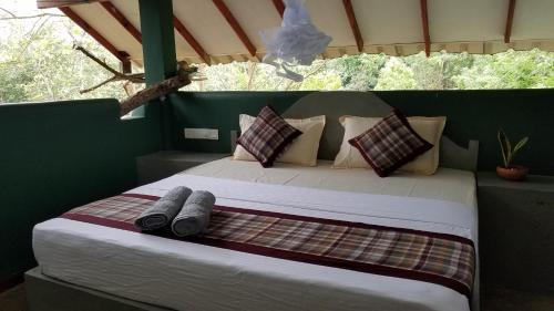 Sigiri Holiday Villa في سيجيريا: سرير في خيمة عليها حذاءين