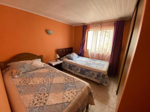 ein kleines Schlafzimmer mit 2 Betten und einem Fenster in der Unterkunft Arriendo de Casa en Pichilemu in Pichilemu