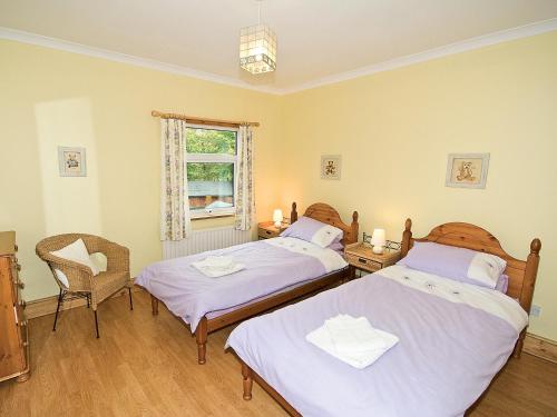 a bedroom with two beds and a window at Hollybush Cottage - E2800 in Cheddleton