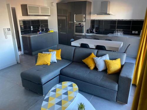 un salon avec un canapé bleu et une cuisine dans l'établissement La Petite Escapade, à Seynod