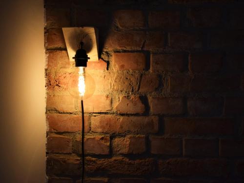 a light bulb on a brick wall in a room at Green Garden Station in Zagreb