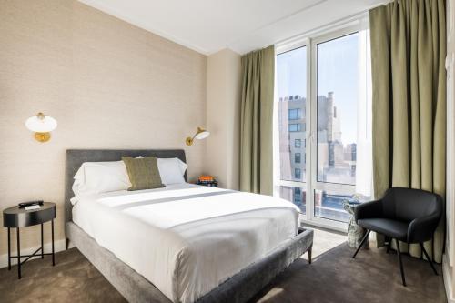a bedroom with a bed and a large window at NoMo SoHo in New York