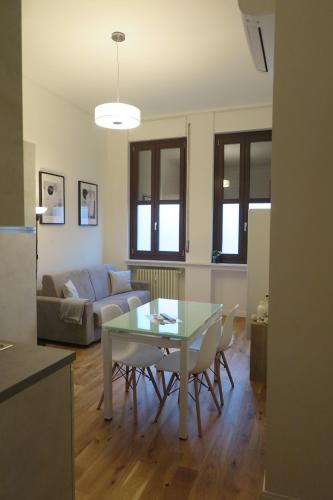 - un salon avec une table en verre et un canapé dans l'établissement Incantevoli Appartamenti Navigli, à Milan