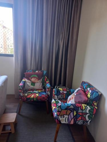 dos sillas sentadas una al lado de la otra en una habitación en Apartamento em Curitiba completo e perto de tudo, en Curitiba