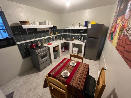 a small kitchen with a table and a refrigerator at The Sleepy Mouse in Cusco