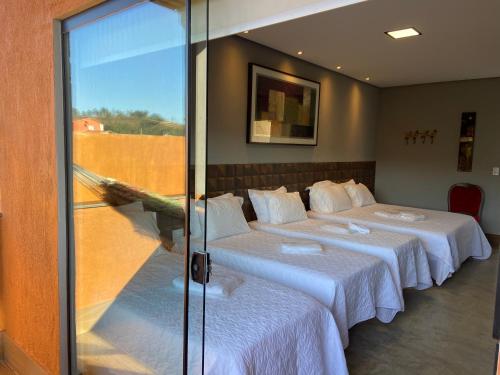 a room with two beds and a glass wall at Pousada Guardiã da Canastra in Vargem Bonita