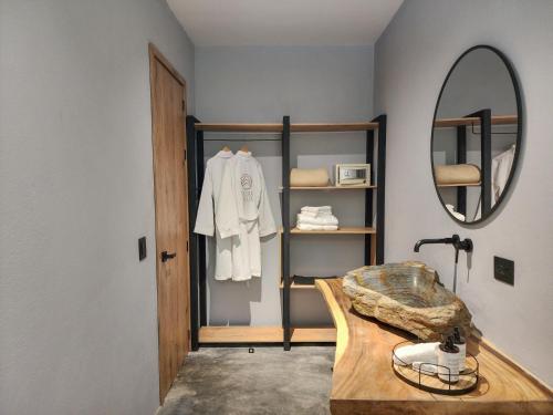 een badkamer met een spiegel en een houten wastafel bij Hotel Piedra Mulata - Adults Only in Doradal