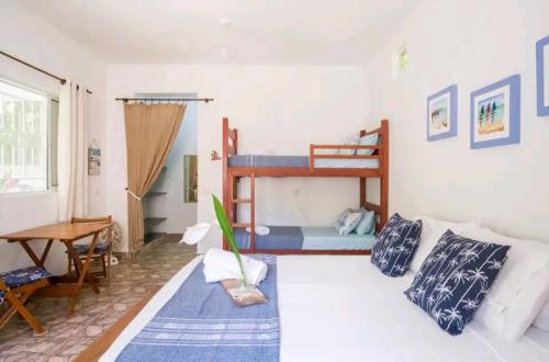 sala de estar con cama y sofá en Loft Praia Brava - Suíte com Área Gourmet Privativa, en Ubatuba