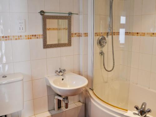 a bathroom with a sink and a shower at Stoker Loft in West Mersea