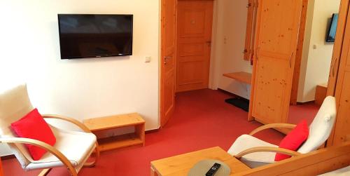 a room with chairs and a tv and a table at Villa Helvetia in Bad Elster