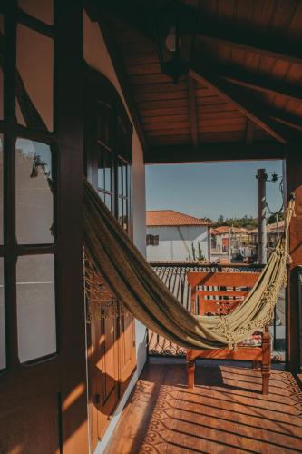 a hammock on the balcony of a house at Hospedaria de Alice in Tiradentes